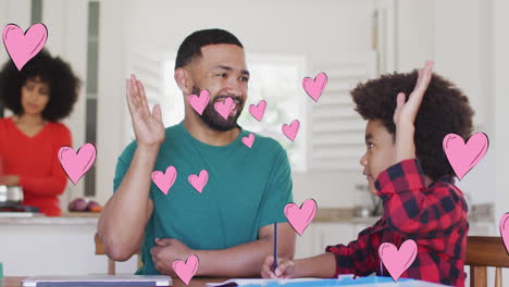 animation of social media heart icons over smiling biracial man and son high fiving