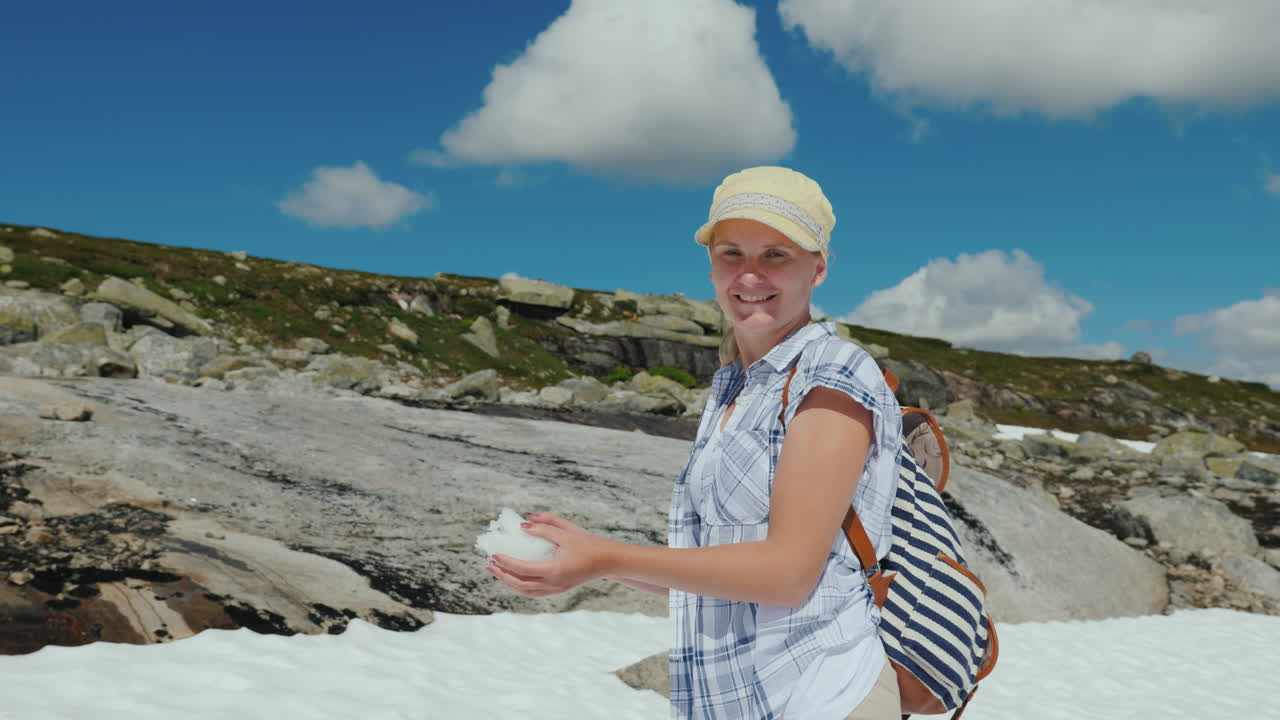 mujer feliz jugando bolas de nieve en un glaciar en noruega verano caluroso pero la nieve aún no se ha derretido - th