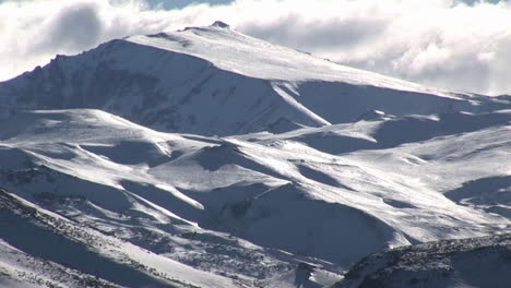 A-snow-covered-mountain-with-clouds-above