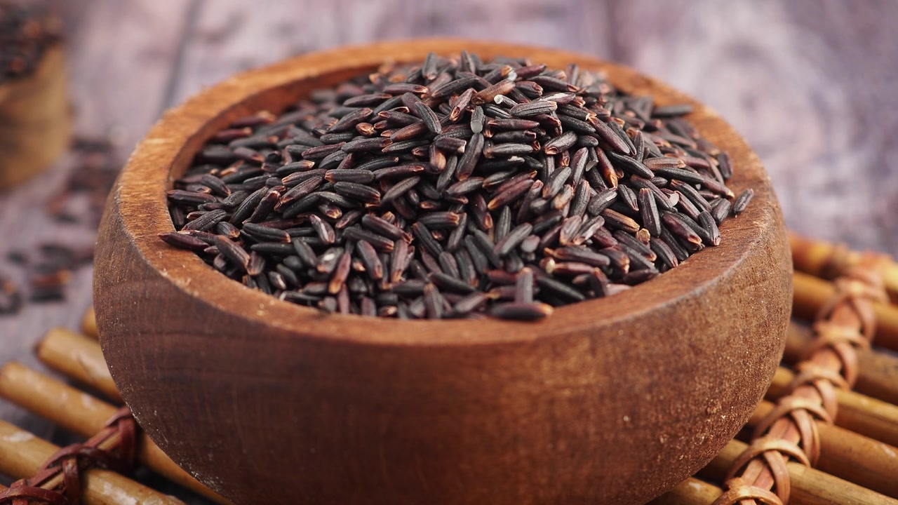 Organic Black Rice in a Wooden Bowl on a Rustic Table