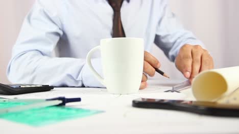 un joven empresario está bebiendo café en la oficina.