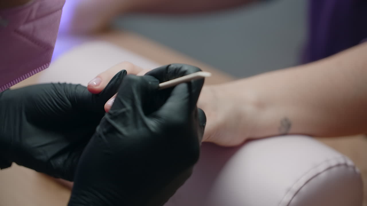 una mujer haciendo una manicura en un salón.