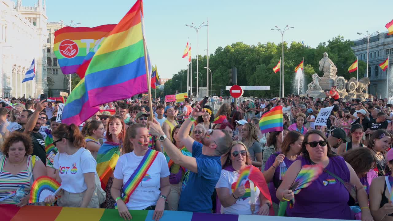 At Cibeles Square, thousands march in Madrid's LGBTQIA Pride Parade, waving rainbow flags to protest LGBTI discrimination and hatred.