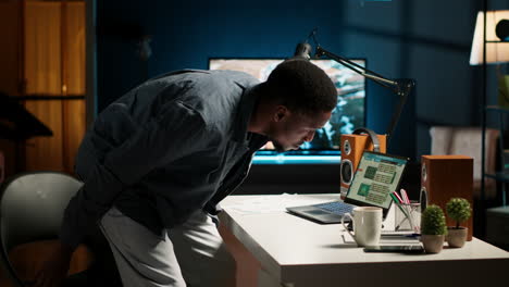 african american guy sitting at his home office and researching data