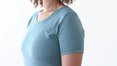 sección media de una mujer afroamericana que usa una camiseta azul con espacio de copia en un fondo blanco