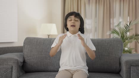 Relaxed-Indian-boy-doing-breathe-in-breathe-out-exercise