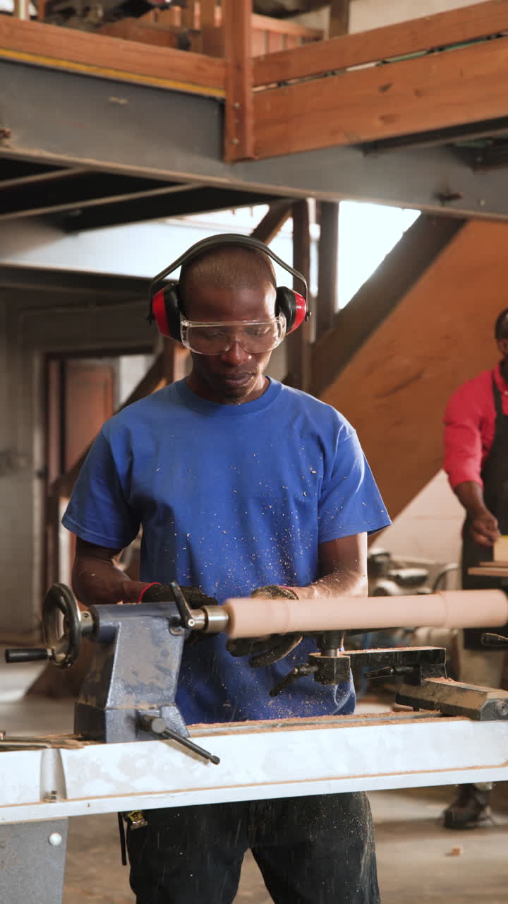 Vertical video: African American coworkers measuring board and consulting at shop, shaping cylinder