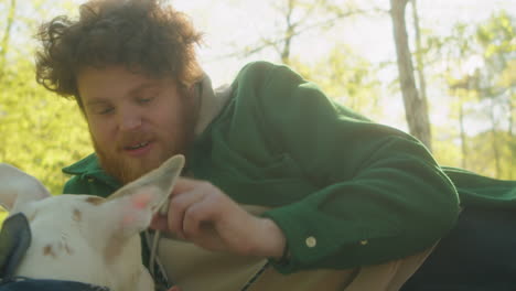 man and dog enjoying a sunny day in the park
