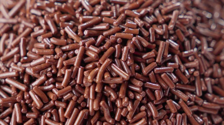 close view of Chocolate sprinkles falling from above onto a giant pile