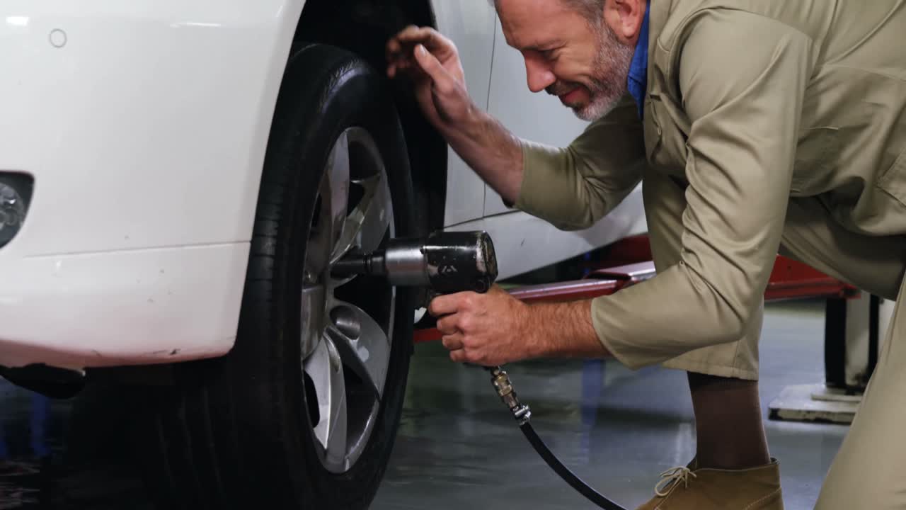 mecánico arreglando una rueda de coche