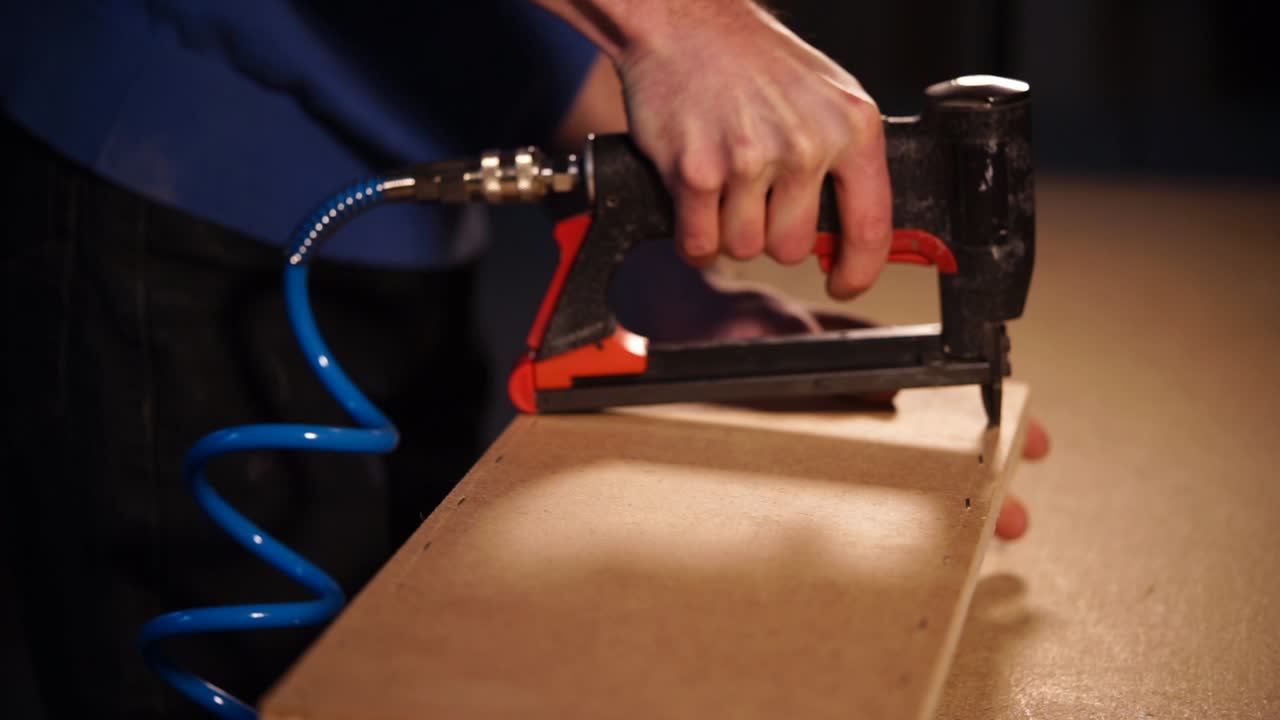 usando una pistola de clavos para montar madera