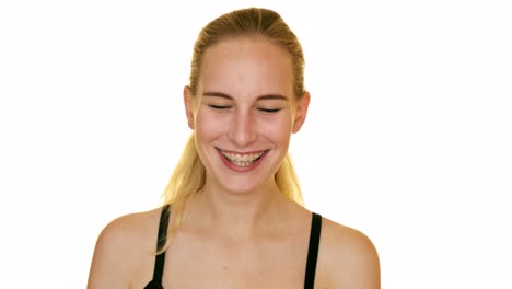 young blond woman laughing in the studio on a white background