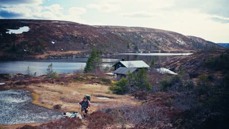 male hiker walking with his dogs near reinsjoen lake in norway - wide shot