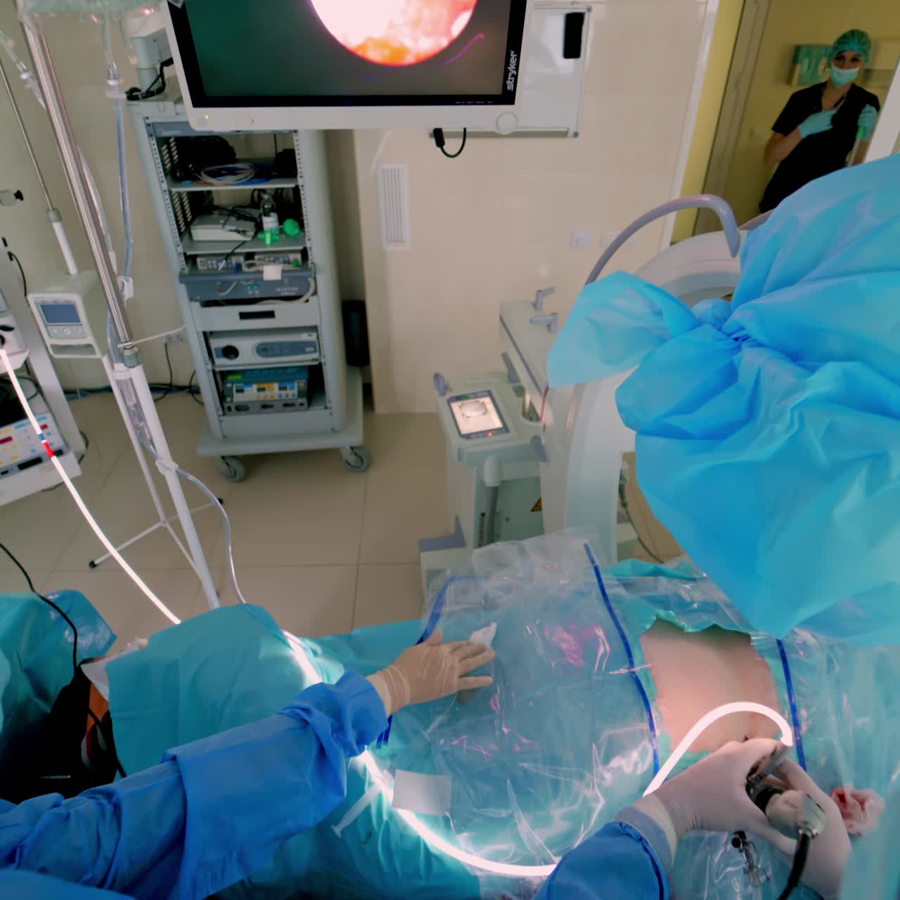 Team of surgeons performing operation in bright modern surgery room. Operating theatre. Modern equipment in clinic.