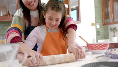 Feliz-Madre-E-Hija-Birracial-Extendiendo-Masa-Y-Sonriendo-En-La-Soleada-Cocina