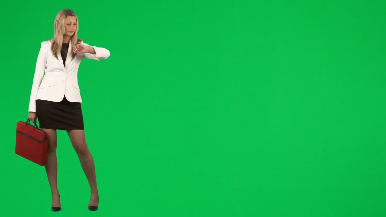 geschäftsfrau wartet auf einen transport gegen den grünen bildschirm.
