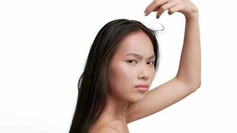 young asian woman examining her hair and scalp