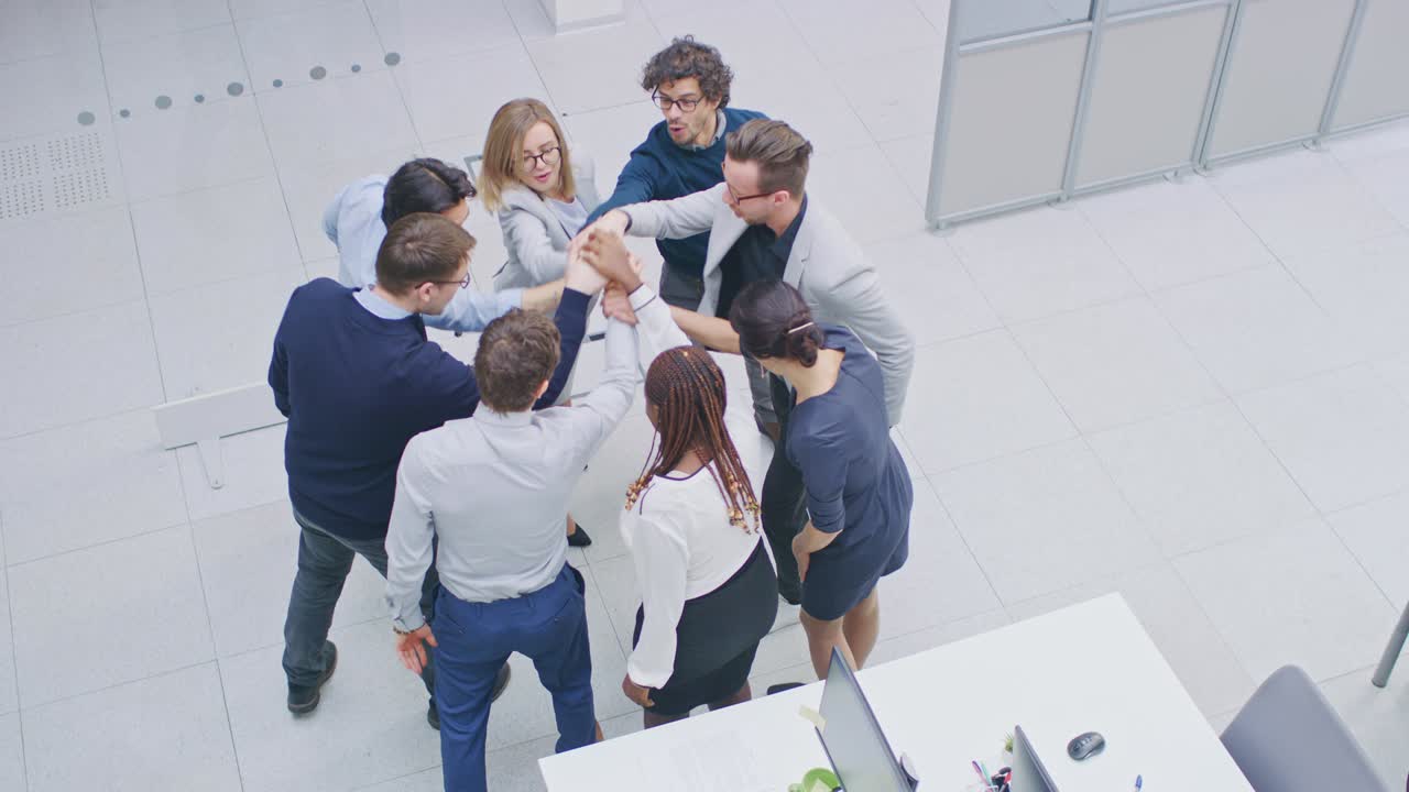 trabajadores de oficina haciendo ejercicio de team building apilando las manos juntos en el espíritu unificador de la creatividad y la causa común. ocho personas exitosas aplaudiendo juntos. fotografía de ángulo alto en una oficina moderna
