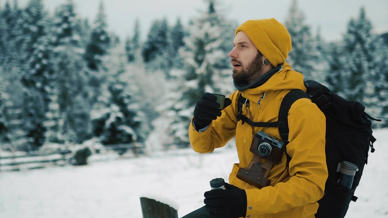 Man drinking tea in snowy forest