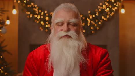 headshot guardando la telecamera felice vecchio barbuto babbo natale indossando costume e agitando la mano video chiamando in zoom registrazione video felicità di natale saluto faccia vista della telecamera. alta qualità 4k filmati