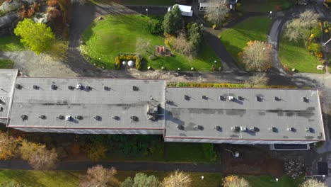 Aerial-dolly-left-over-building-roof-on-sunny-day