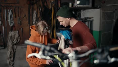 master and apprentice: fixing a bicycle wheel in the garage