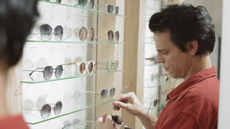 man trying on sunglasses in an optical store