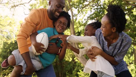 Cute-family-is-playing-rugby-in-a-park-