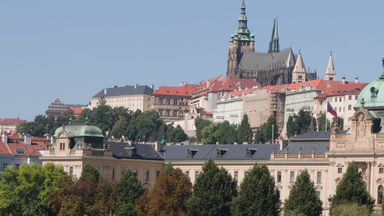 Panoramica lenta sul Castello di Praga, edifici storici e alberi rigogliosi sotto la luce del giorno