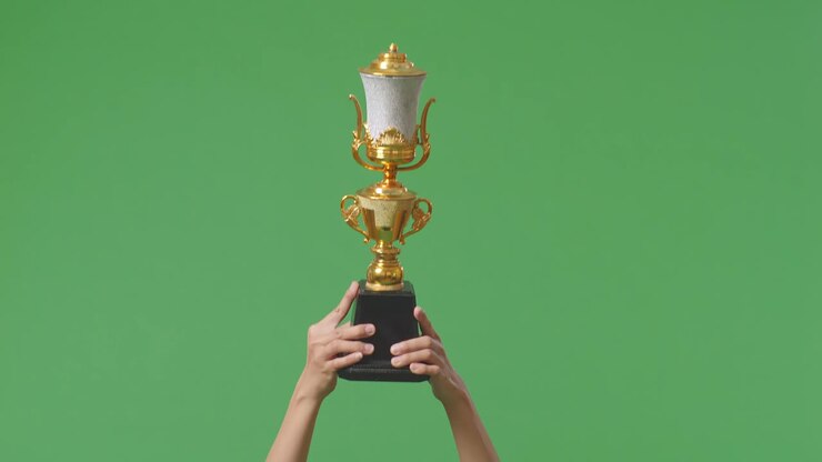 поднятые руки женщины держат трофей. зеленый фон экрана