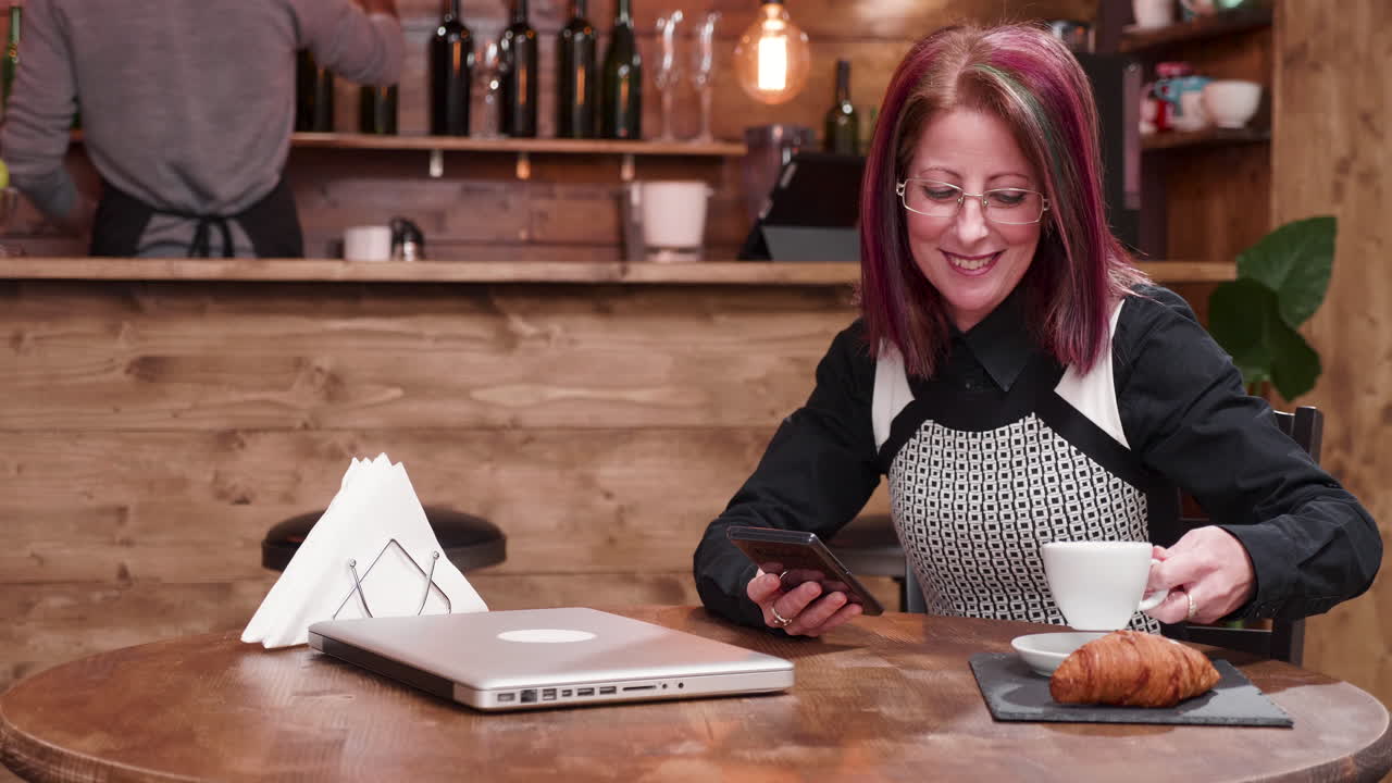 mujer usando un teléfono móvil en un café