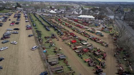 high aerial view of an amish mud sale auctioning buggies, farm equipment to quilts on a winter day