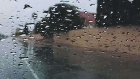 Gotas-De-Lluvia-En-El-Parabrisas-Del-Coche-Mientras-Se-Conduce-Por-La-Calle