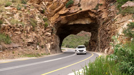 cars drive through tunnel at historic kogmanskloof mountain pass on r62, montagu