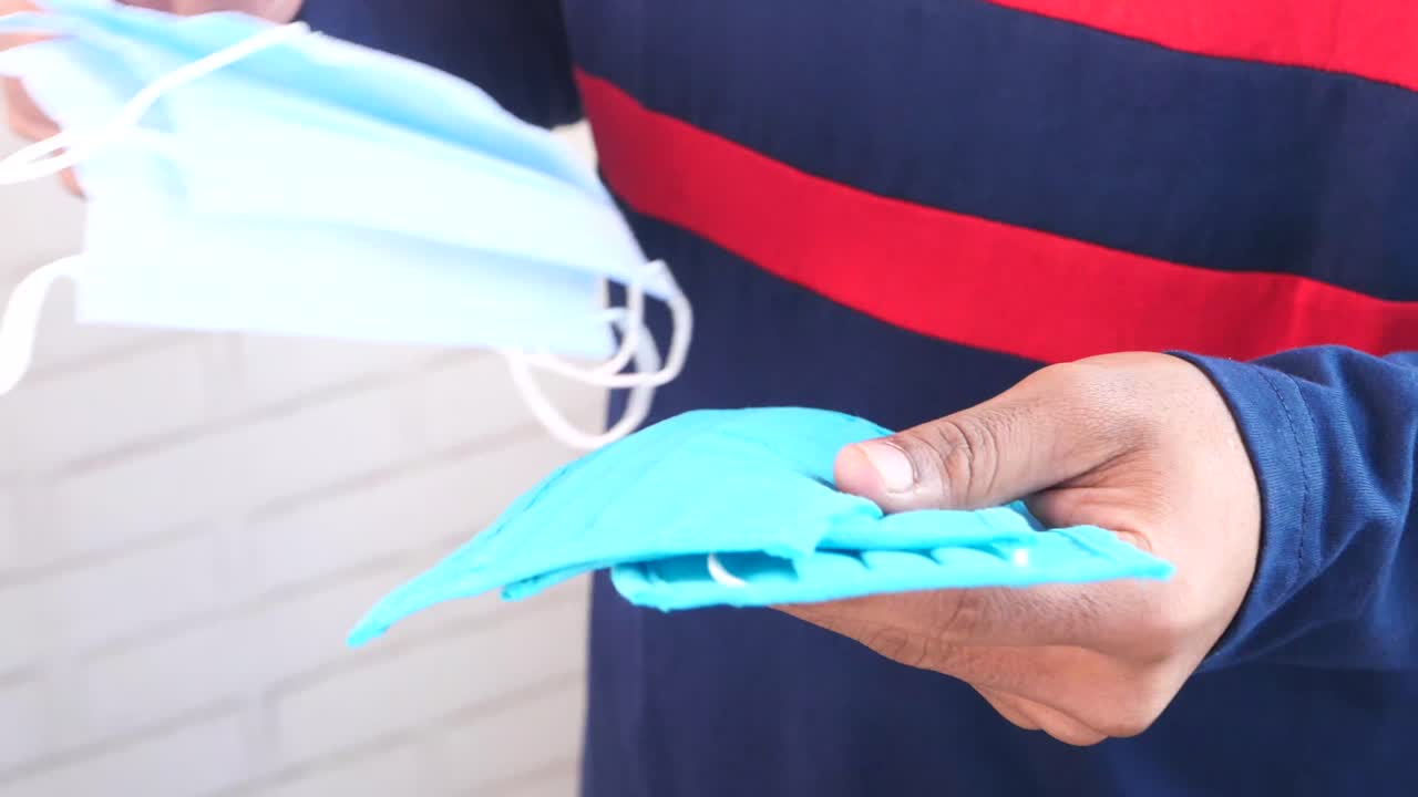 persona que maneja y apila máscaras desechables