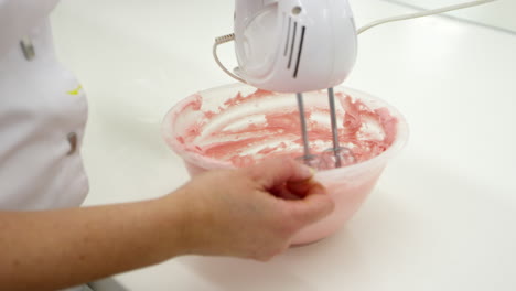 Mujer-En-Panadería-Mezclando-Glaseado-Con-Batidor-Eléctrico