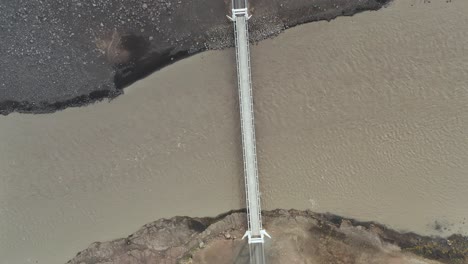 top down aerial of remote jokulsa bridge in north iceland, brown glacial river