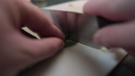 Close-up-footage-of-a-person-chopping-green-onions-on-a-cutting-board