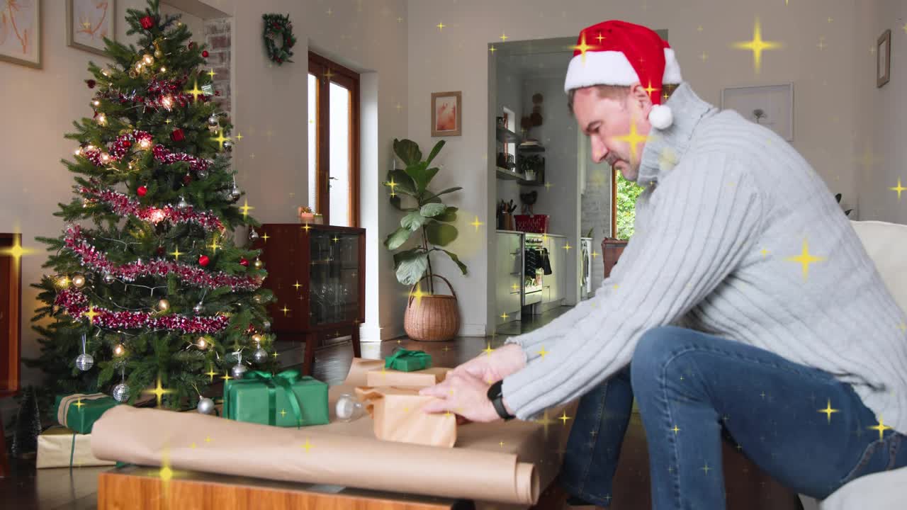 Man kneeling pulling kraft paper, wrapping gifts by tree, animated sparkles accenting holiday prep