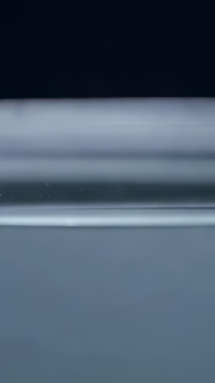 Video verticale: goccia d’inchiostro nero rilasciata che scende perforando l’acqua del serbatoio, formando una scura colonna
