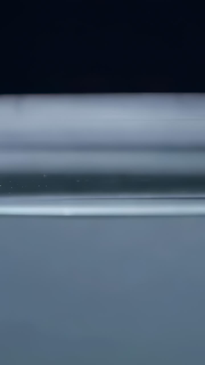 Video verticale: goccia d’inchiostro nero rilasciata che scende perforando l’acqua del serbatoio, formando una scura colonna
