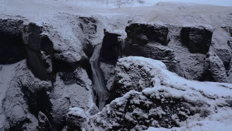 panning shot of massive icelandic fjadrargljufur canyon during cloudy winter day in iceland