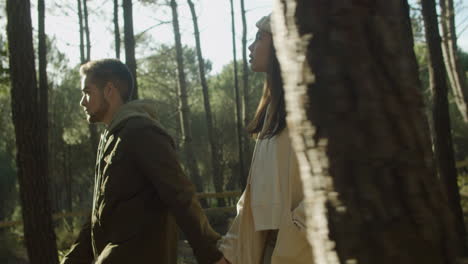 hermosa joven pareja caminando en el parque en el soleado día de otoño