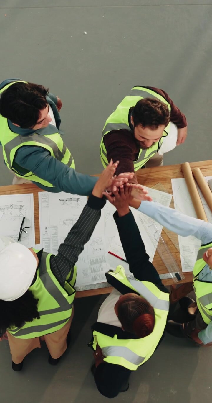 Team eterogeneo di architetti esamina i progetti in un cantiere edile