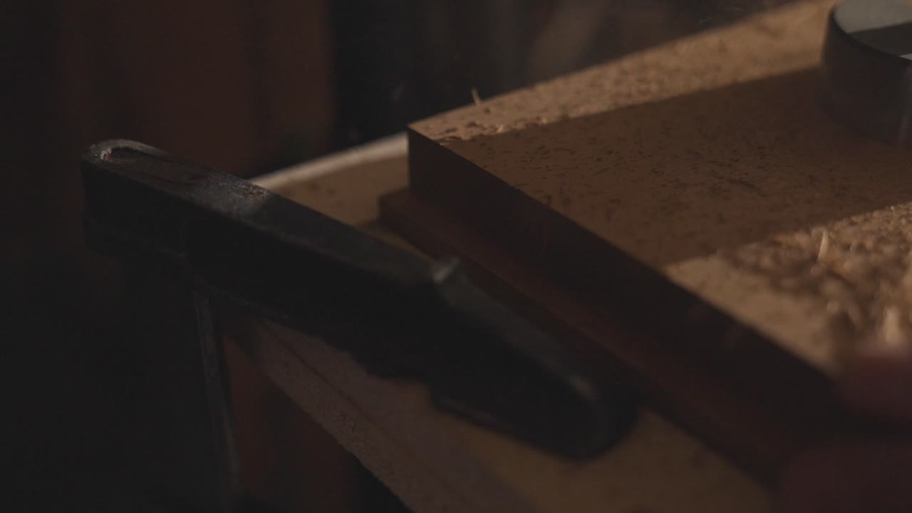 Wood shavings flying away from drill milling machine hole cutting in board