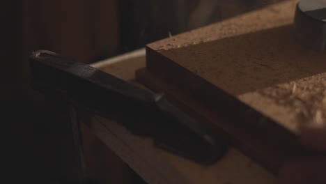 wood shavings flying away from drill milling machine hole cutting in board