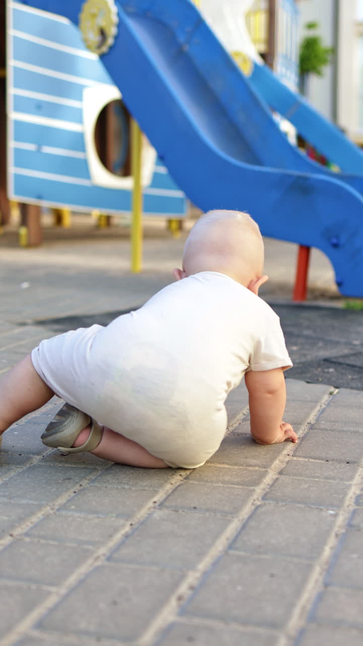 Un bambino disegna con il gesso sull'asfalto durante una passeggiata. Un bambino disegna con il gesso. Abbigliamento estivo per bambini.