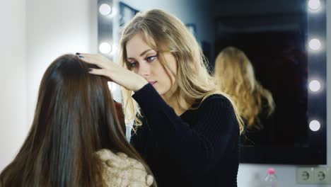 makeup artist does a young woman's make up in studio 4