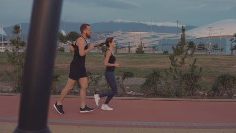 pareja corriendo en un parque cerca de un estadio