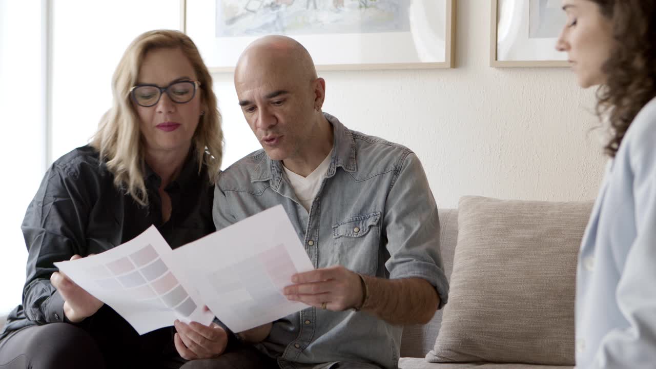 vista frontal de los propietarios maduros eligiendo el color para la renovación